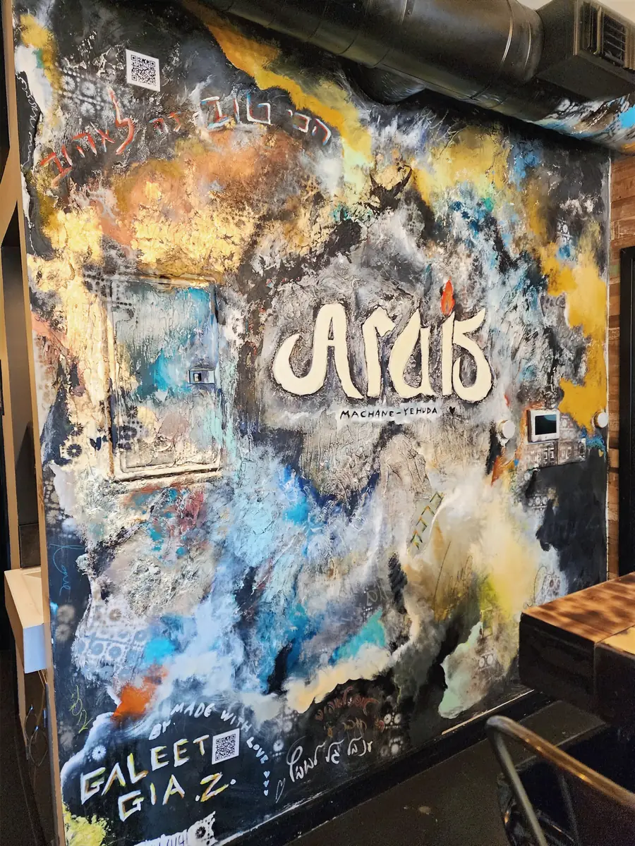 A dark mural with gold, blue and cream textures around the Arais restaurant logo