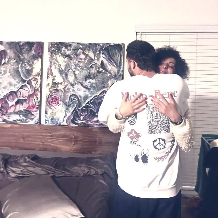 A client hugs Galeet in front of his commissioned diptych
