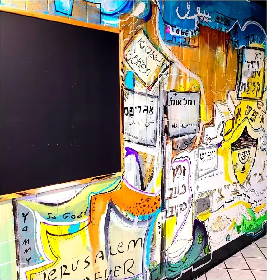 Close-up of the Jerusalem market mural: hand-painted Hebrew street signs, a menorah and the words Jerusalem Forever