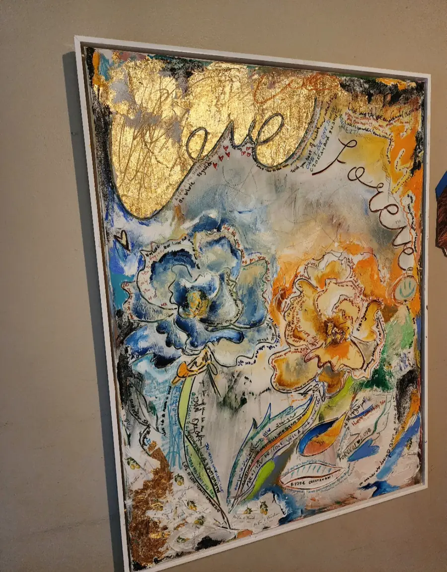 A finished wedding canvas with gold leaf, blue florals and the words Love Forever, hanging on a wall